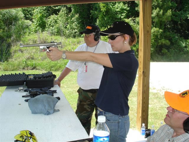 Sue Lifsey of Chapin takes aim with a .22 semi-automatic pistol as instructor Michael Andrews looks on.